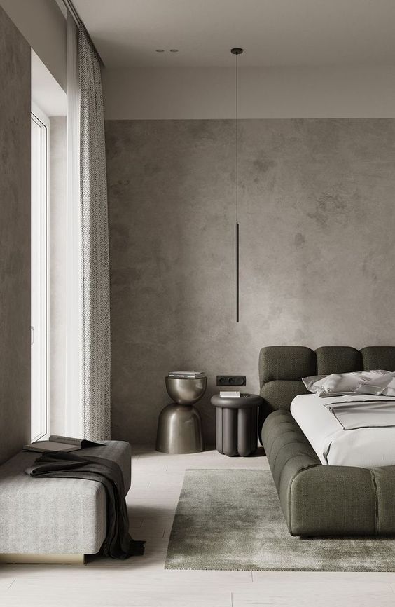 a sophisticated modern bedroom with grey limewashed walls, a dark green upholstered bed, pretty nightstands, an upholstered bench