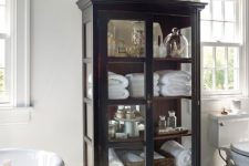 a stylish vintage black cabinet with glass doors and sides is a lovely idea for a bathroom, you will add a vintage feel to it easily