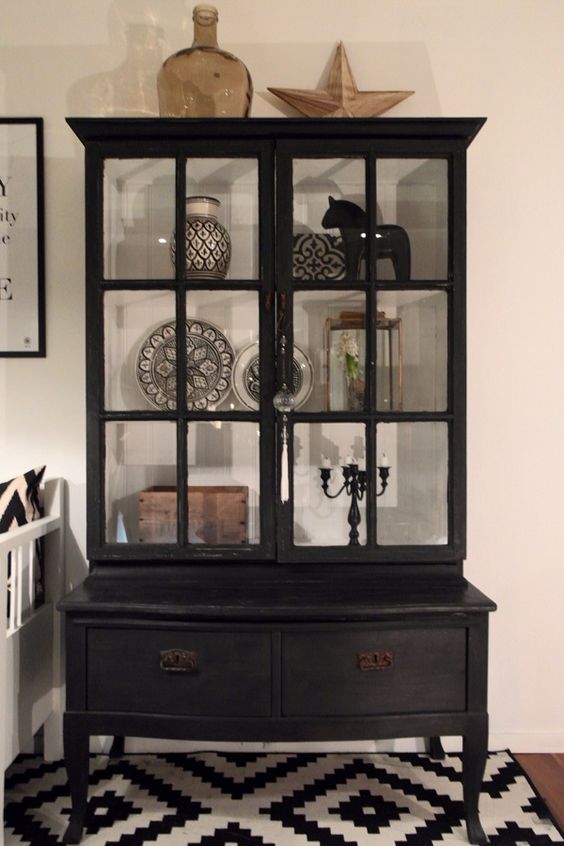 a vintage black armoire with usual drawers and glass doors that allow you display beautiful things inside and make them stand out