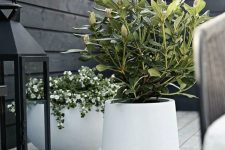 a white bowl and usual curved planter with blooms and a large plant are amazing for a Scandinavian or modern home