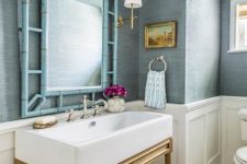 light blue grasscloth wallpaper goes nice with white paneling and gold touches, with a light-stained vanity