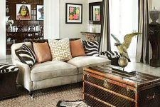 04 a bold living room with a grey sofa, zebra print pillows, a faux zebra rug, a dark chest for storage and some elegant black furniture pieces around
