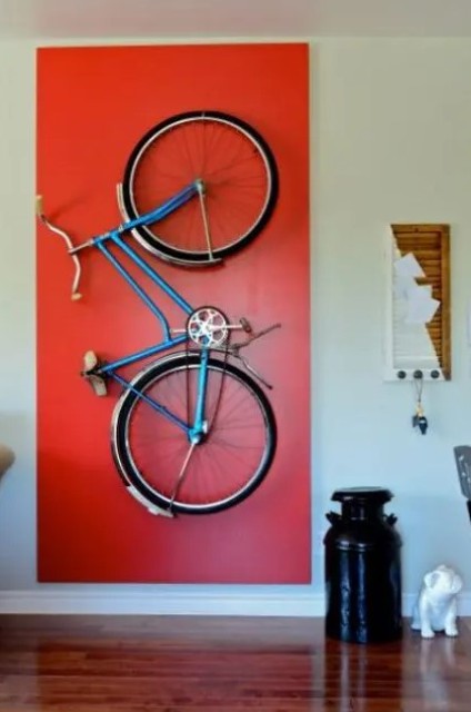 a holder for storing the bike on the wall and a bold red accent to highlight it is a very cool idea to accent what you really like