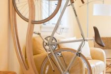 09 a lovely wall-mounted wooden bike holder is a very chic and elegant idea for any space is a gorgeous idea for a modern space