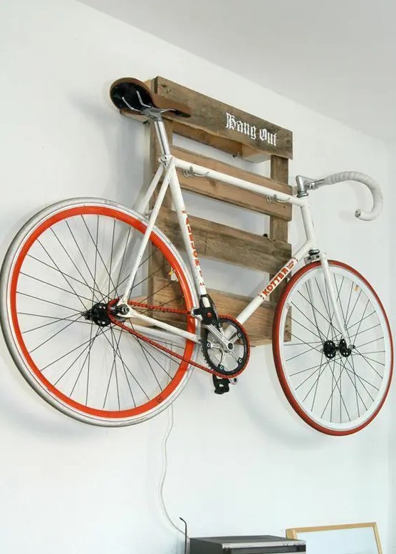a pallet shelf holding a bike is a cool idea for a rustic or industrial space and it can be placed anywhere