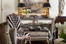 11 a sophisticated living room in neutrals, with a zebra print rug, vintage carved furniture pieces, black table lamps and cool art