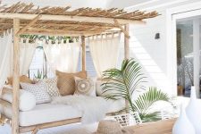 18 a welcoming tropical terrace with a wooden table, white metal chairs, a bench with a roof and lots of pillows