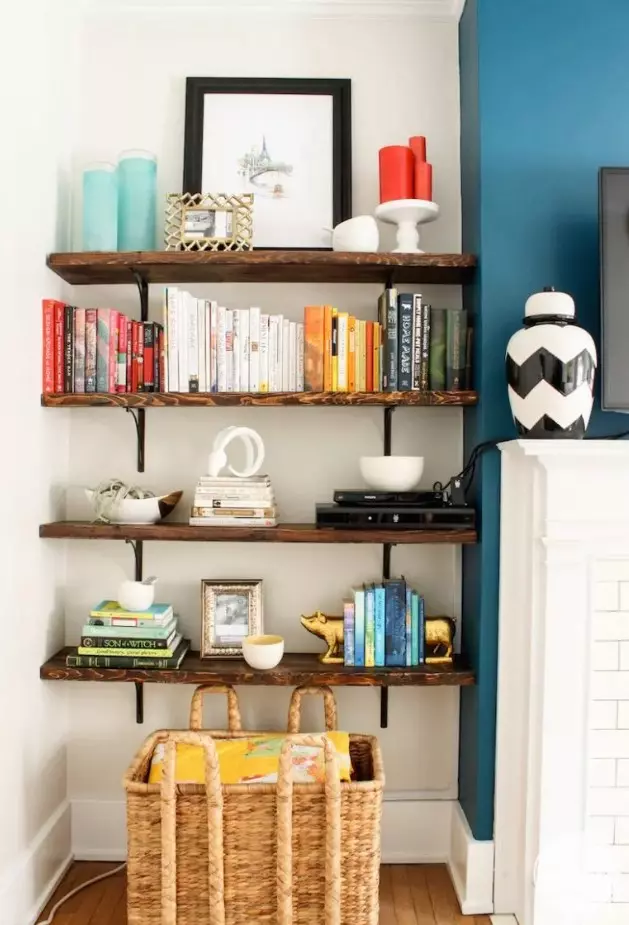a router placed on a shelf makes part of decor like stacked books is a lovely idea to hide it right in the sight