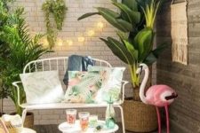 25 a mini tropical deck with potted greenery, a pink flamingo, colorful candle lanterns, elegant white forged furniture and lights