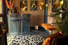 27 a bold space with a character, with cheetah print wallpaper and a rug, black and orange stools, a brown chair and vintage artwork on the wall