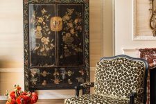 28 an exquisite space with beautiful wallpaper, a vintage floral painted sideboard, a cheetah print chair and a black coffee table wows