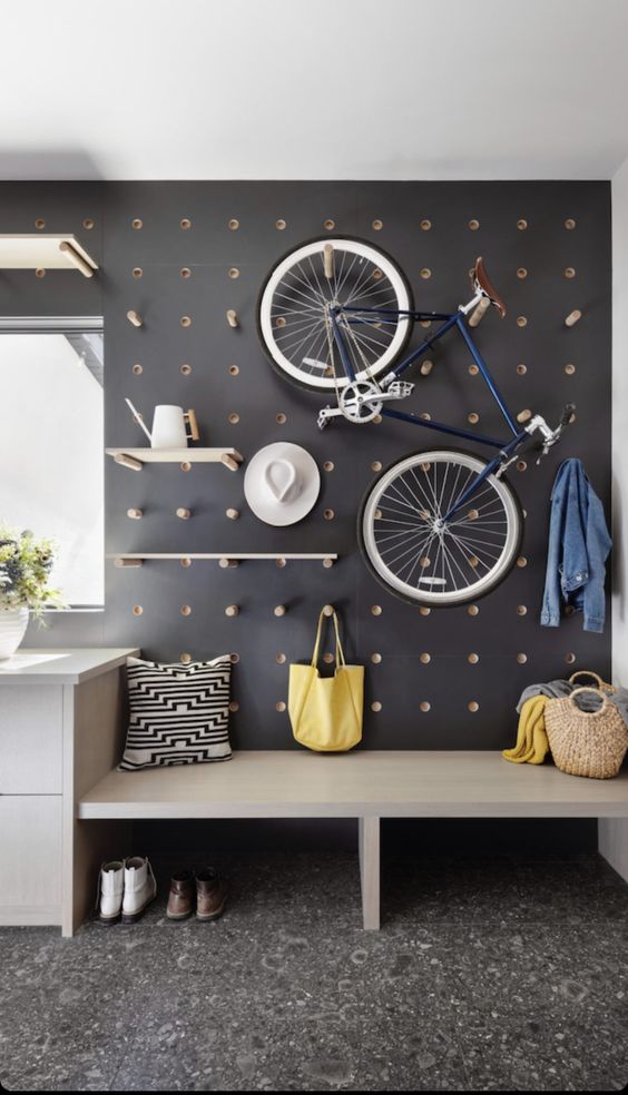 a black pegboard is a universal solution for storage and organizing, here you may attach not only shelves but also a bike