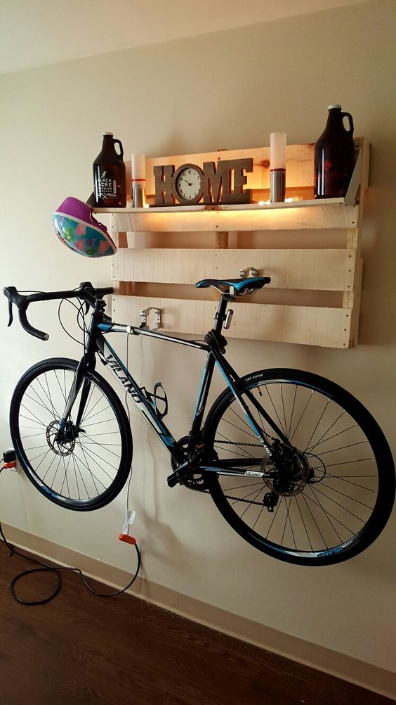 a crate wall mounted shelf with lights and candles can be used to display things and to store a bike is a lovely idea