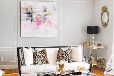 31 a glam midwest living room with grey walls, a white sofa with white and leopard print pillows, a grey pouf and a mustard chair plus a zebra print rug