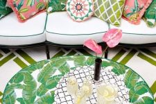 31 make up a boho patio with a large neutral sofa with colorful pillows and a tropical leaf print table
