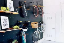 34 a light-filled entryway with a black pegboard wall with lots of shelves, hangers, hooks and with bike holders is a gorgeous idea for a contemporary space