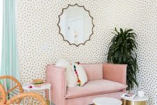 35 a lively living room with Dolmatin print walls, a pink loveseat, a rattan chair, shiny gold coffee tables and potted plants is amazing