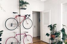 35 a serene and airy living room with a bright printed rug, potted greenery, a metal pillar with holders for bikes and a shelf with a plant