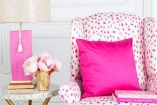41 bright pink nook with a hot pink Dolmatin print chair and a pillow, a side table with a hot pink table lamp and a yarn decoration on the wall