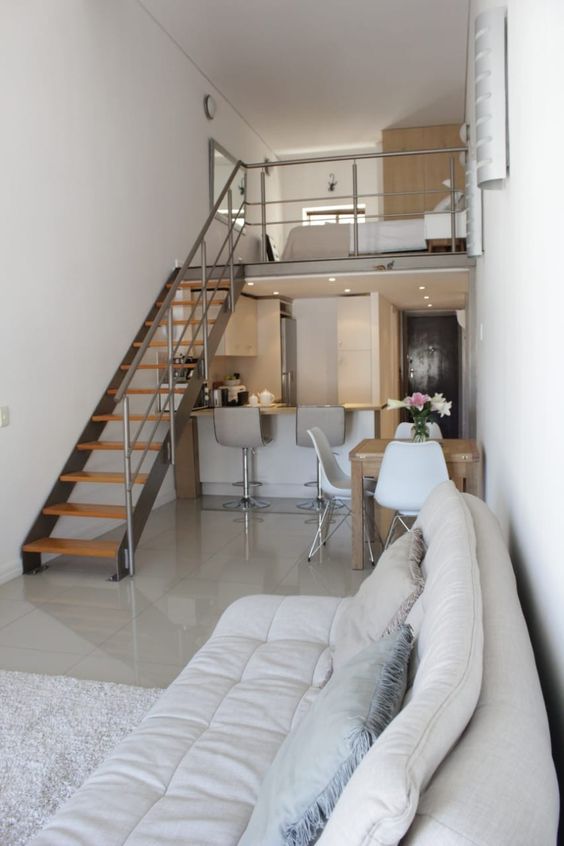 a contemporary home with a restraint color scheme, with a loft sleeping space and a dining-kitchen-living room below