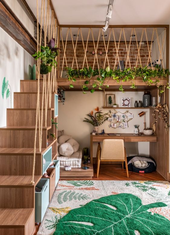 a lovely boho space with a loft sleeping space, a home office and a sofa in the corner, lots of greenery and a botanical rug to refresh the space