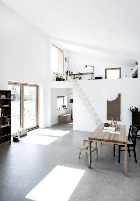 a minimalist spacious home with a loft working space, potted greenery and a dining room down the stairs