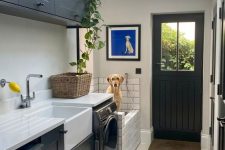 a modern farmhouse laundry with a skylight, black shaker style cabinets and a dog shower is a practical idea
