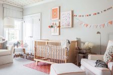a pretty Scandinavian nursery with light grey walls, a star print ceiling, neutral seating furniture, a gallery wall and chic kid’s furniture