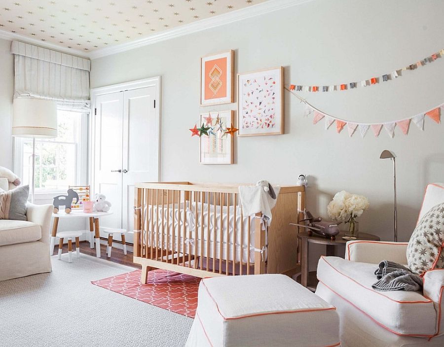 a pretty Scandinavian nursery with light grey walls, a star print ceiling, neutral seating furniture, a gallery wall and chic kid's furniture