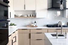 a pretty modern kitchen with whit and stained cabinets, comfrotable handles, white stone countertops and a white marble backsplash