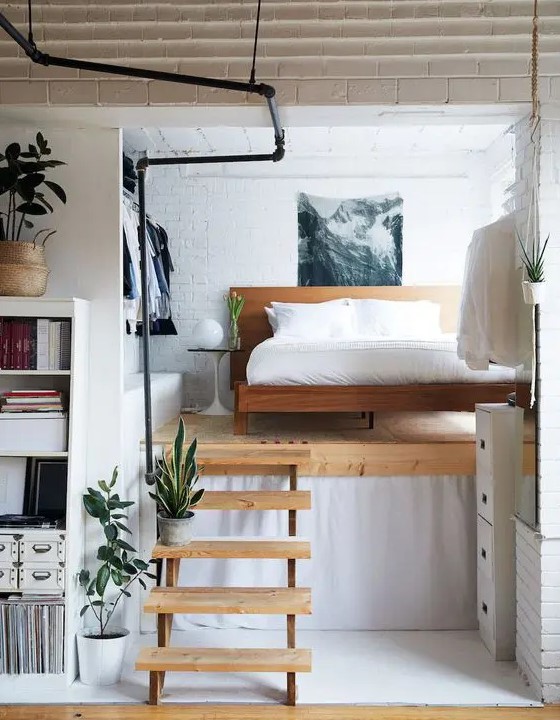 a small and chic modern loft bedroom with a wooden bed, an open closet and a cool artwork is a bold idea