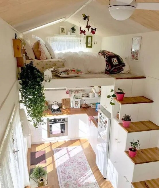 a small house with a loft bedroom and a storage stairs plus a kitchen down contains everything you may need for living
