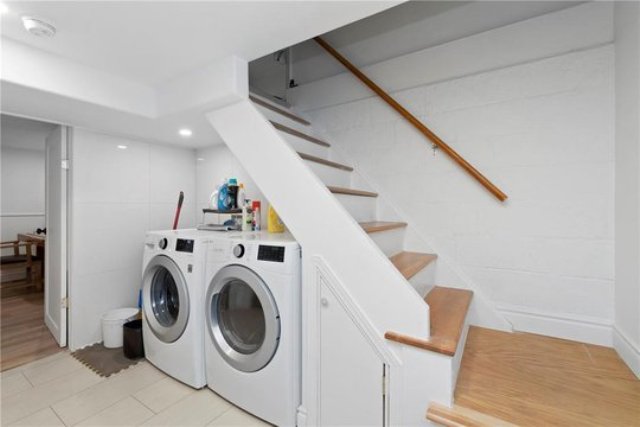 a staircase with a small storage drawers, a washing machine and a dryer and some stuff for storage
