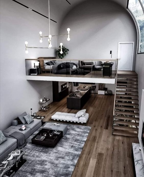 a stylish contemporary apartment with a monochromatic color scheme, a loft bedroom and a living-dining space down the stairs