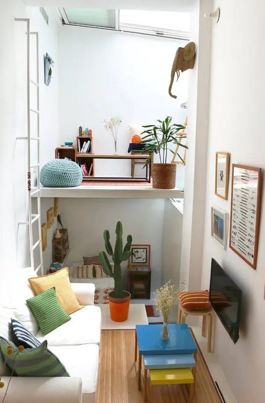 a tiny colorful apartment with a living room, a bedroom down and a loft workspace with a skylight over it is fun