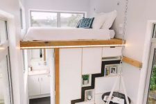 a tiny modern home with a loft bedroom, a storage unit that doubles as a bathroom and a kitchen and dining space below