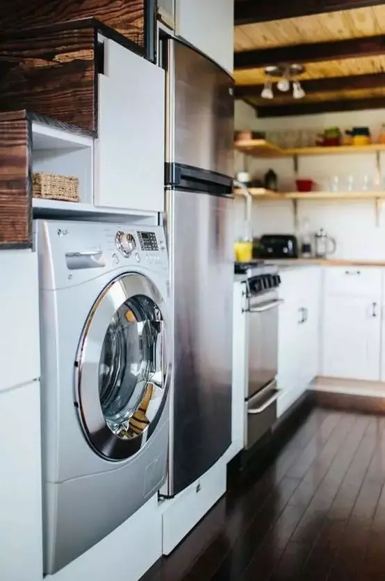 a washer and dryer combo unit built in under the stairs to save some space but with no doors to hide   that makes this laundry part of the kitchen