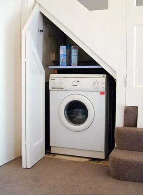 even a small staircase can accommodate a tiny laundry like this one and you will use this space to advantage