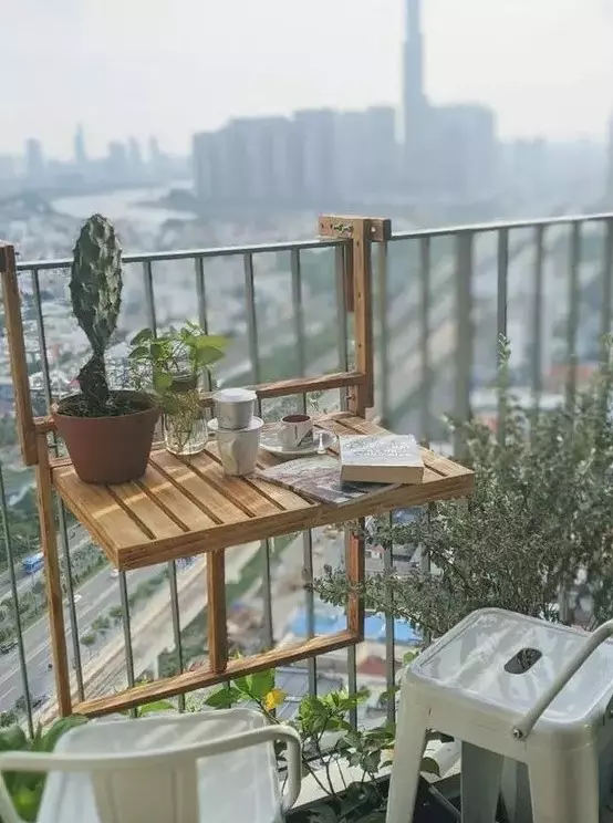a little wooden folding table that can be hung on the railing is a brialliant idea for a tiny or small balcony and it looks eco-friendly and natural