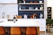 06 a chic modern white kitchen with a navy skinny tile backsplash and amber leather stools