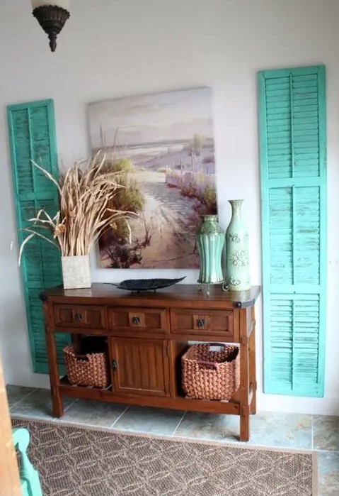 bold turquoise shutters on both sides of a console bring a beach feel to the space