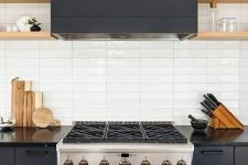 08 a graphite grey kitchen with wooden shelves and a white skinny tile backsplash is very chic and bold