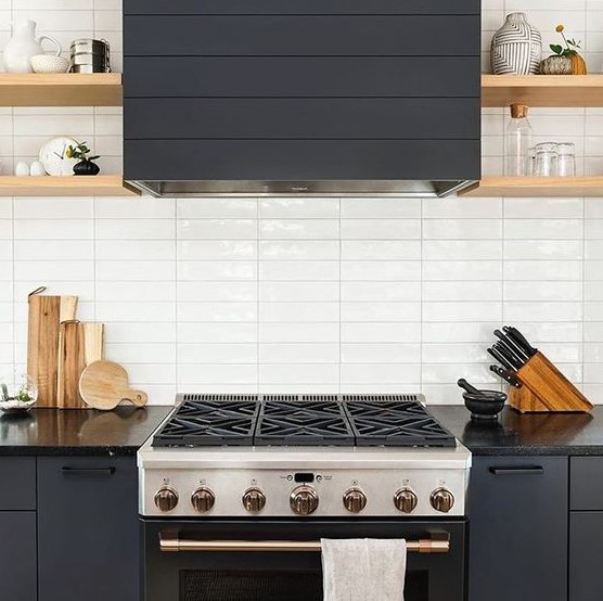 a graphite grey kitchen with wooden shelves and a white skinny tile backsplash is very chic and bold