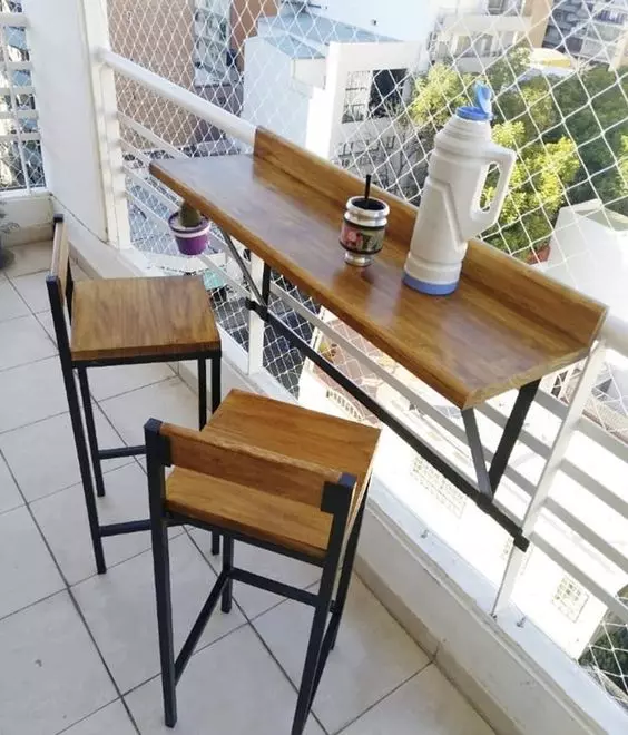a small tabletop attached to the railing and a couple of tall matching stools are ready bar in the space