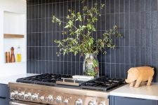 09 a grey kitchen with wooden beams, a black matte skinny tile backsplash and a metal cooker and hood