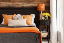a weathered wood wall makes the bedroom more rustic, cozy and welcoming and calms down the bright color scheme