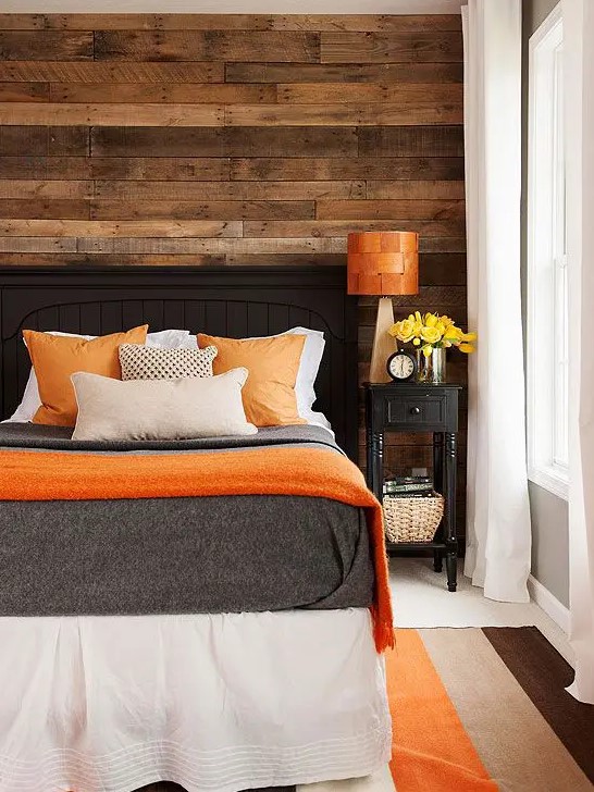 a weathered wood wall makes the bedroom more rustic, cozy and welcoming and calms down the bright color scheme