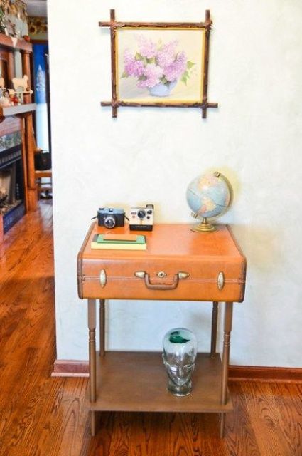 a pretty console table made of a vintage suitcase placed on legs and with a shelf, with cameras and a globe is a lovely idea