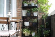 14 a black metal stand with lots of potted plants is the easiest idea to organize a garden in the balcony, and it will save a lot of space