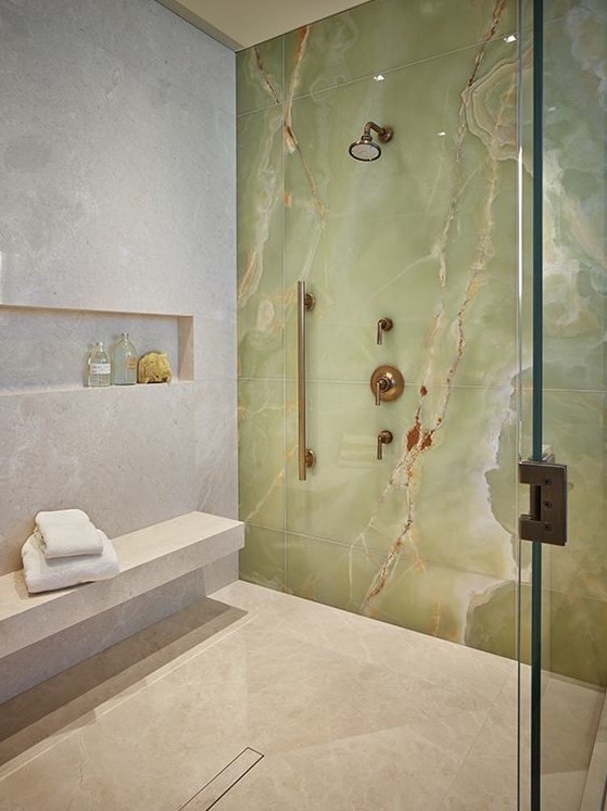 a fantastic shower space in neutrals accented with a green onxy statement wall that really wows